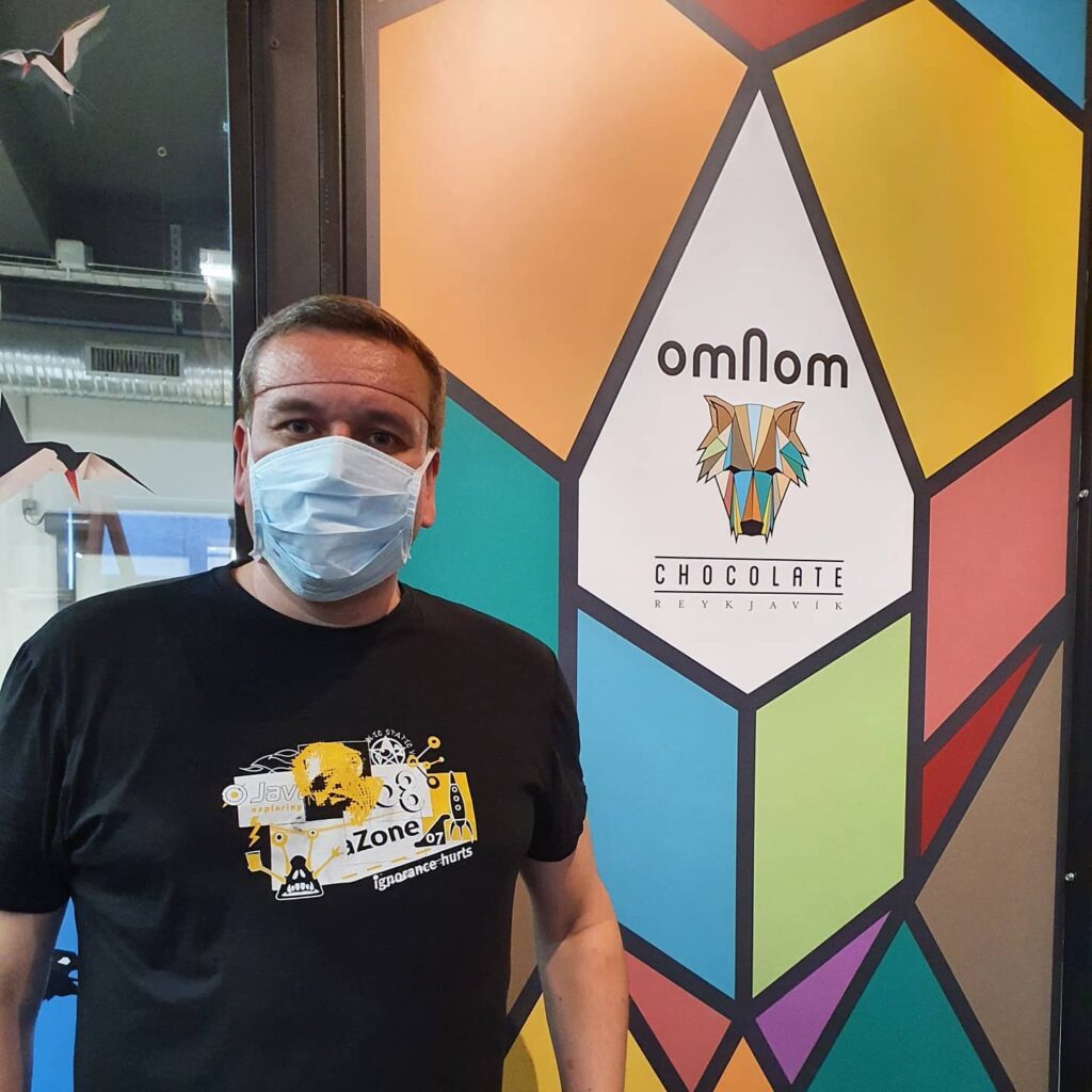 Svein-Magnus Sørensen med munnbind foran Omnom-logoen